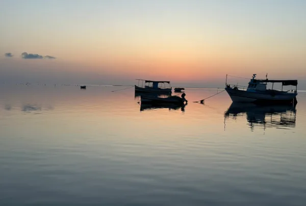A picture of 2 boats mooring in the sea of Kerkennah island during the sunset