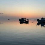 A picture of 2 boats mooring in the sea of Kerkennah island during the sunset
