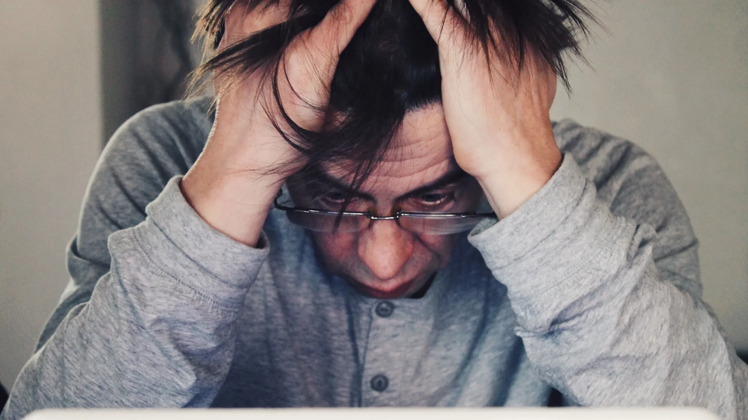 A man holding his head with anxiety expressions on his face.