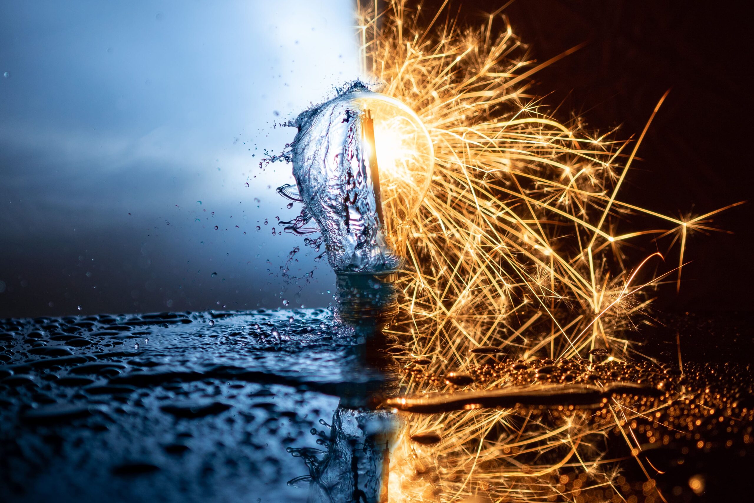 Light bulb split between water and fire, symbolizing the energy-water nexus with splashing water on one side and bright sparks on the other.